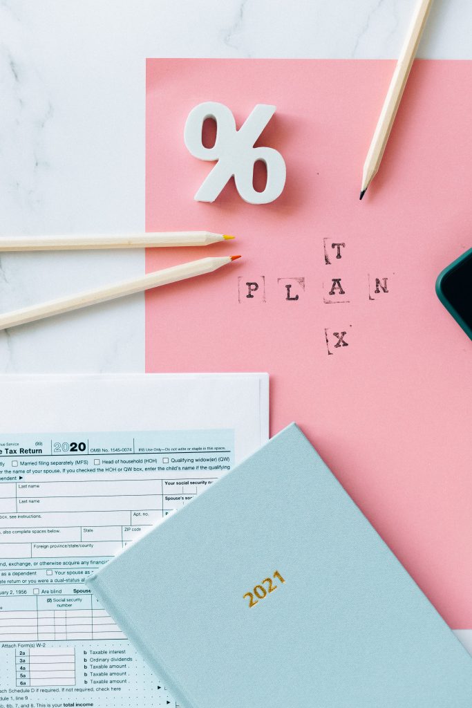 Tax Return Form and 2021 Planner on Pink Surface